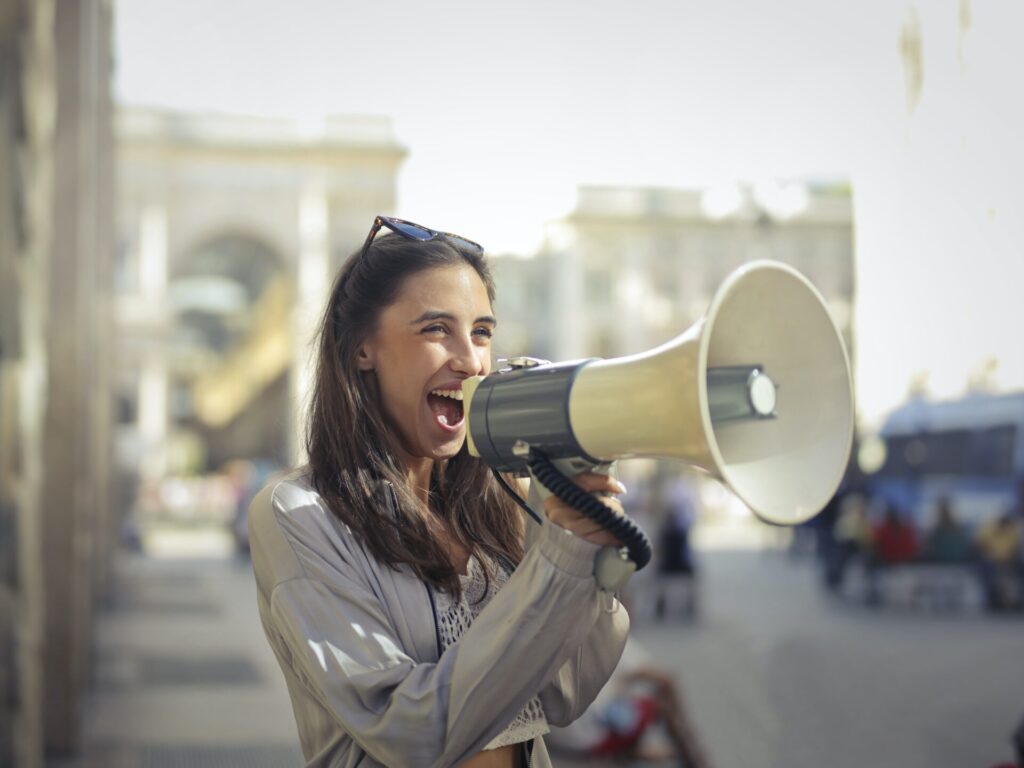 a woman screaming into a megaphone