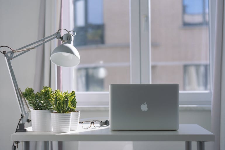 A laptop next to a lamp.