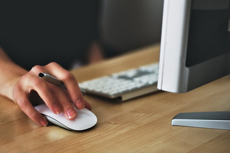 A close-up of a hand using a mouse.