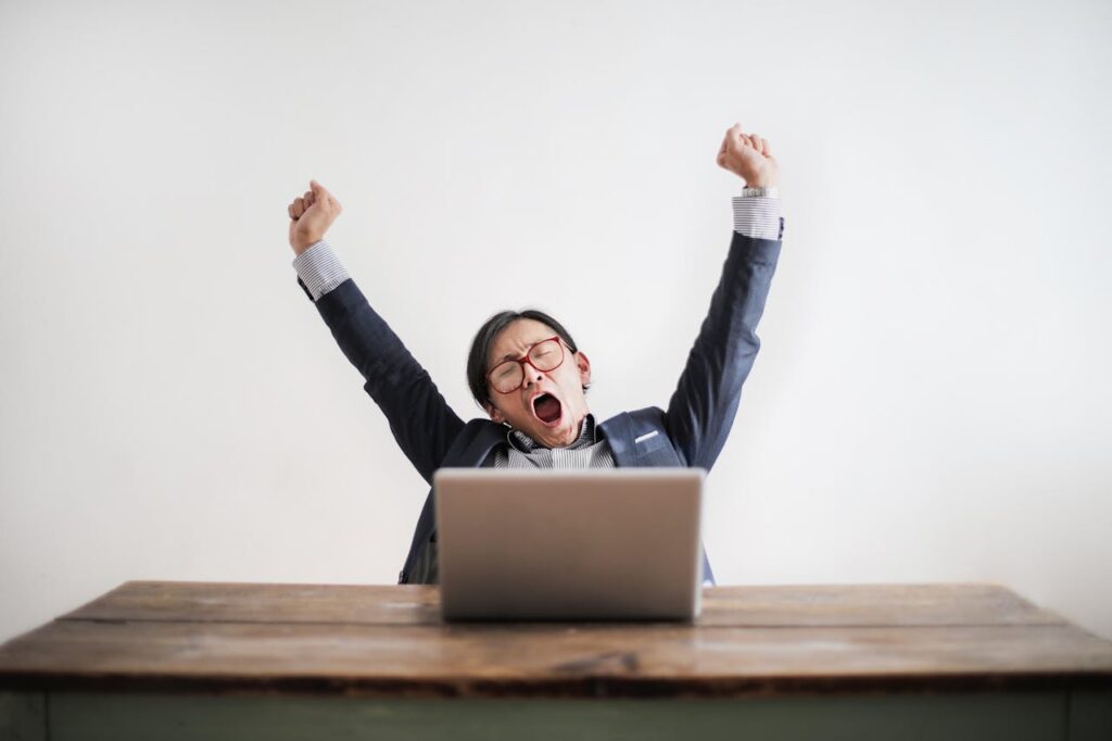 Man yawning in front of his laptop