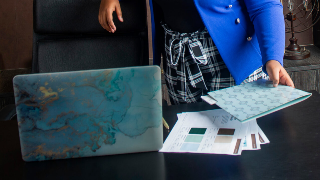 Printed brand presentation document open on a desk, showing brand guidelines and logo usage.